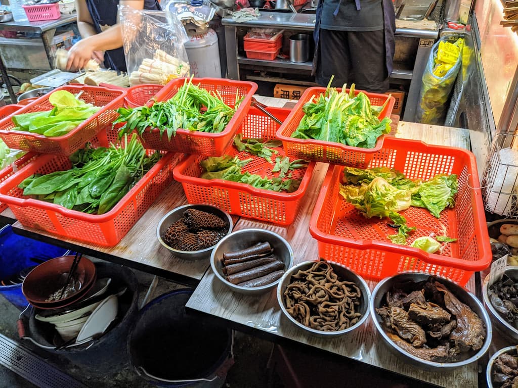 深坑平價滷味攤位上擺放的新鮮蔬菜與牛肚食材選取區