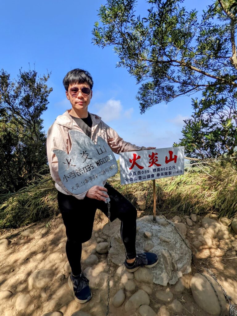 火炎山標高 602 公尺木牌與沾滿紅土的登山鞋